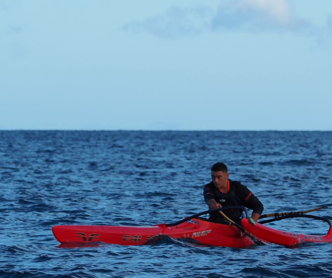 A person paddling in a red canoe