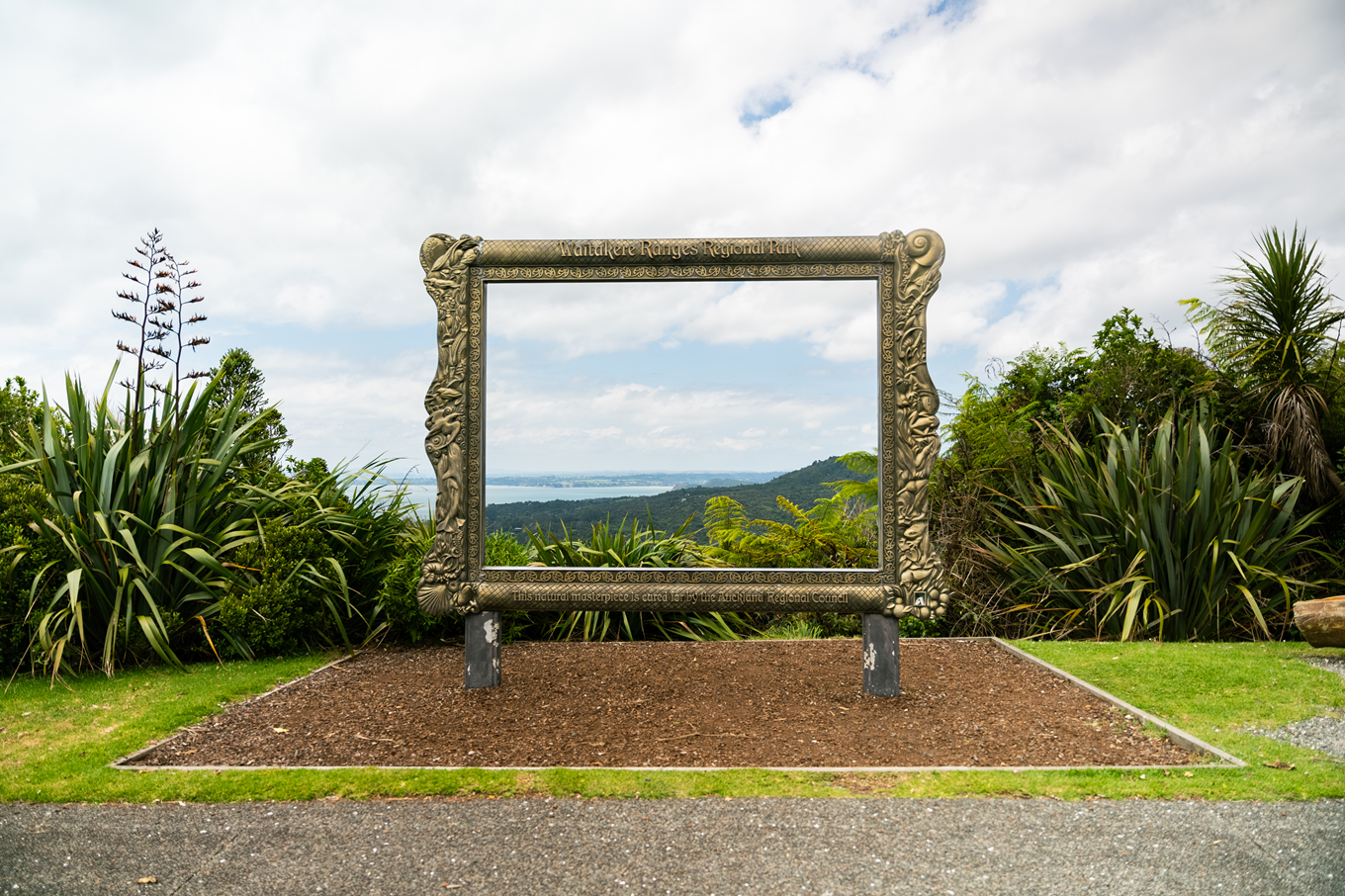 A golden photo frame art piece in the forest. 