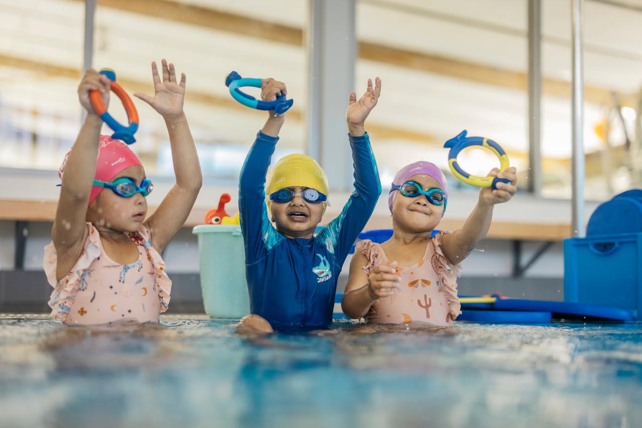 Three kids with swimming goggles on. 