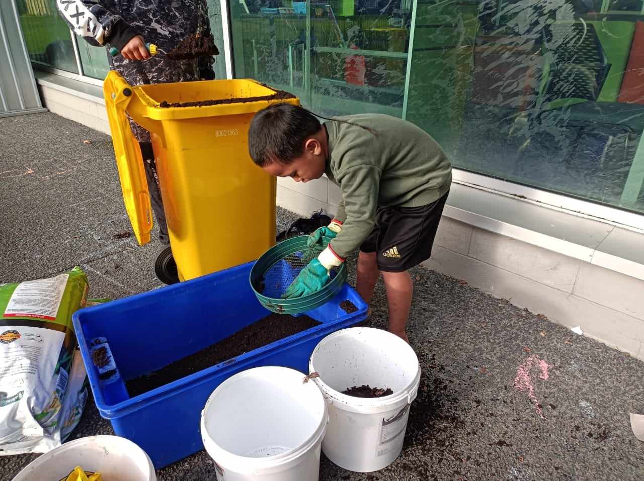 Young boy doing compost.