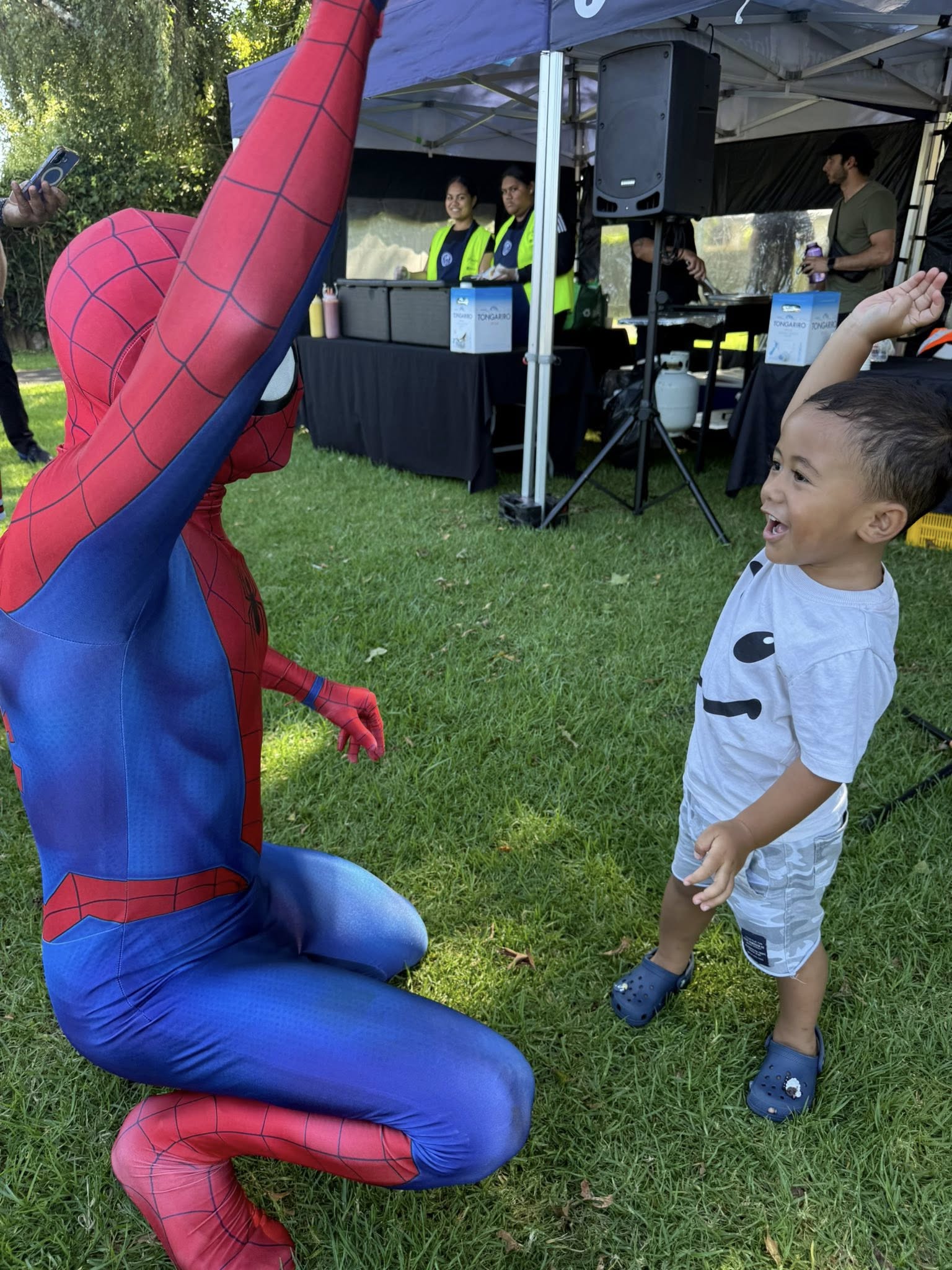 Spider man and a local kid high fiving. 