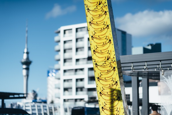 Light sculpture of large pole with bright yellow bananas.