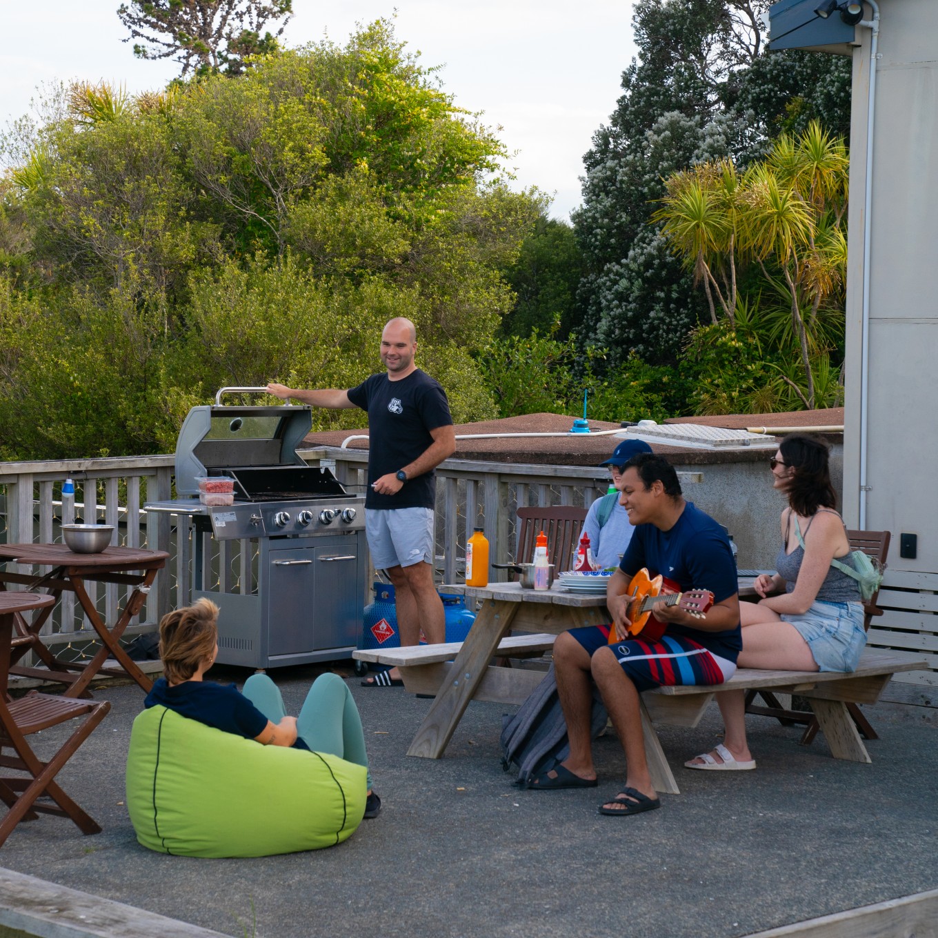 A group of people on a deck having a bbq.