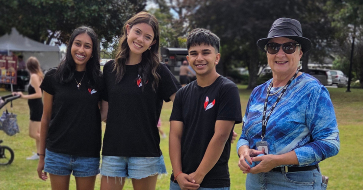 Papakura youth posing for a photo with local board member at community event in the park