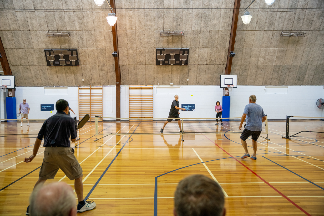 A group of people playing pickleball. 