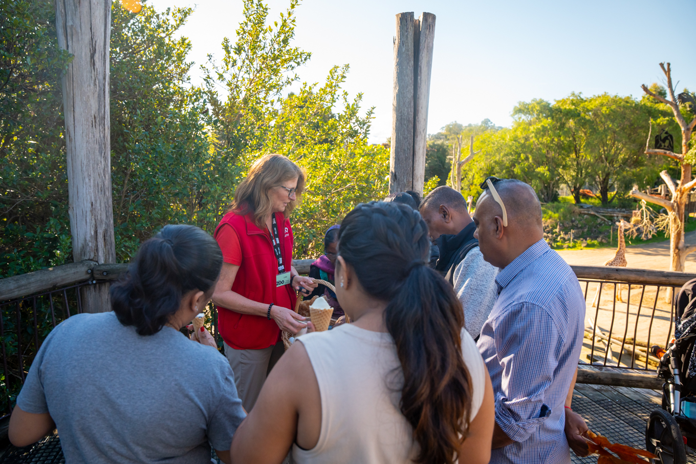 A tour guide showing people around the Safari exhibit of Auckland Zoo.