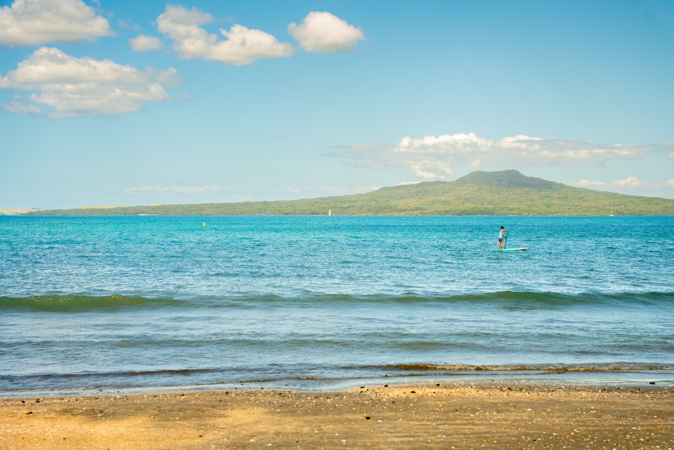 A person bogey boarding at Takapuna Beach. 