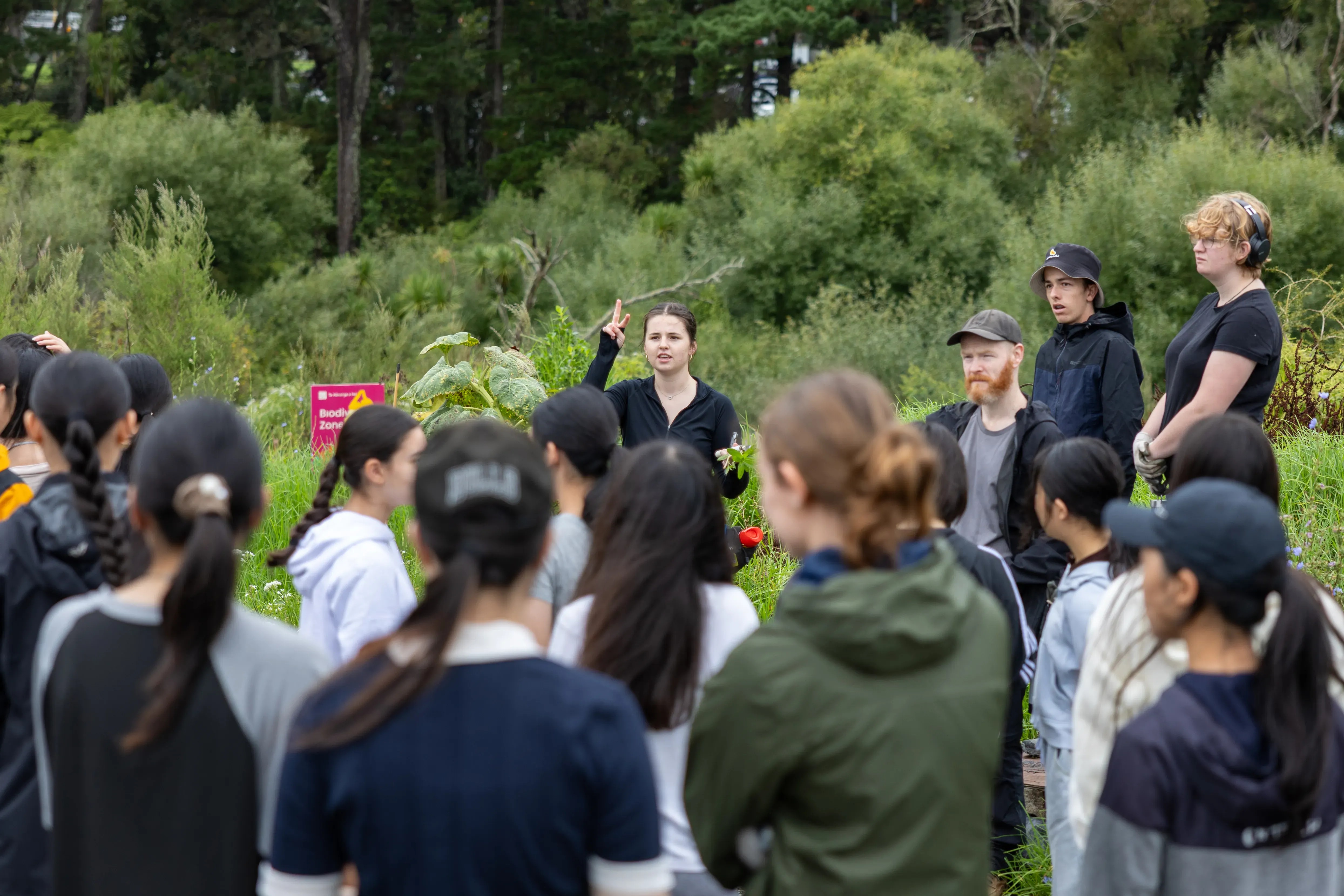 A woman talking to a crowd of people.
