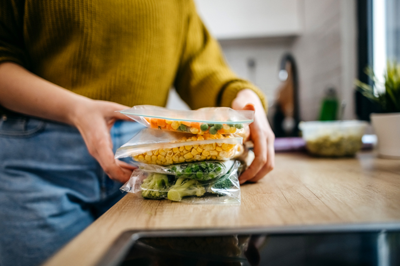 A lady packaging food in sealed bags.
