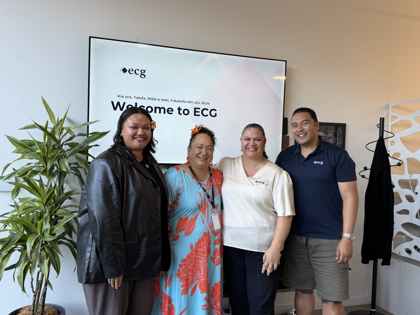 Group of appointed consultants and Auckland Council staff standing in office lobby in front of 'welcome' screen.