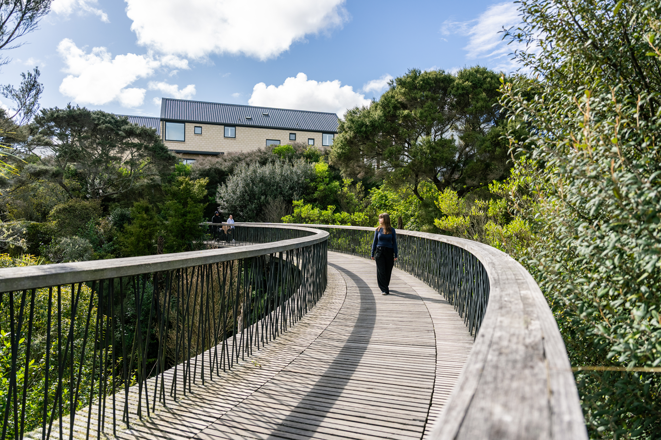 A few people walking on a bridge via the Te Ara Manawa Walkway.
