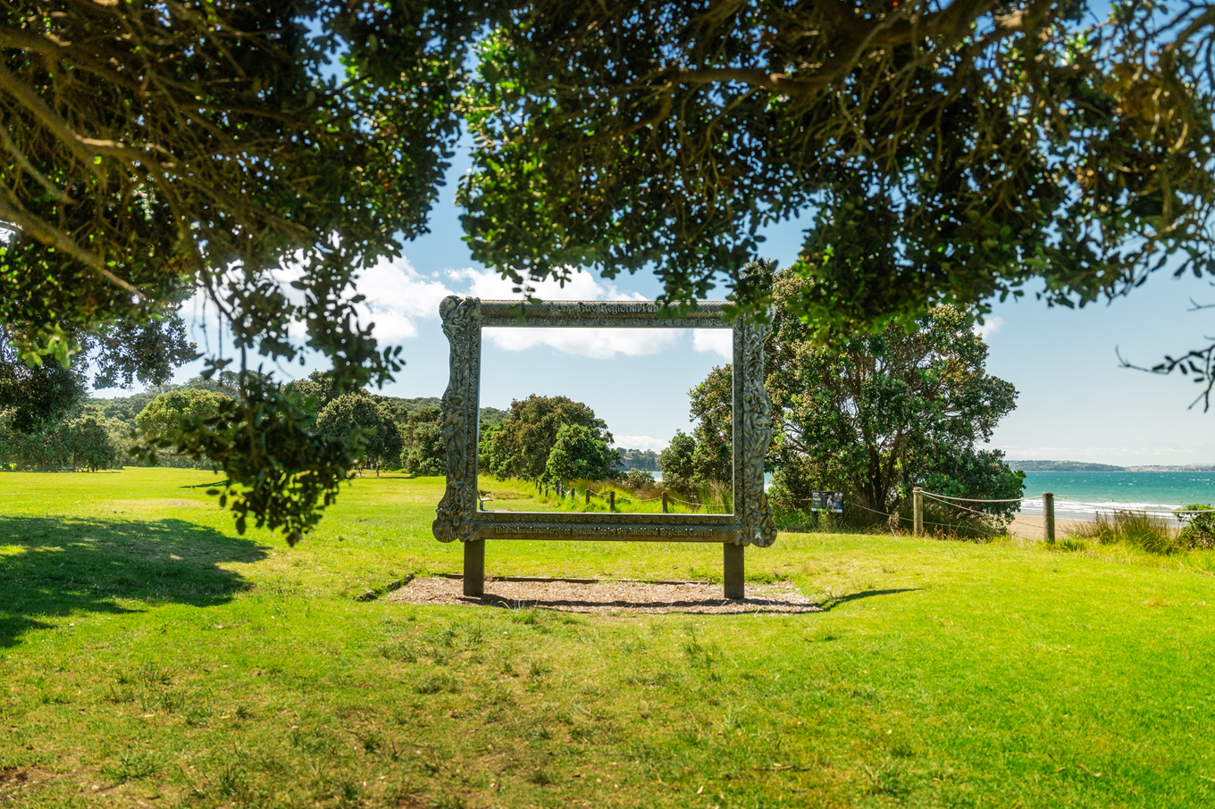 A large photo frame placed in a green area.