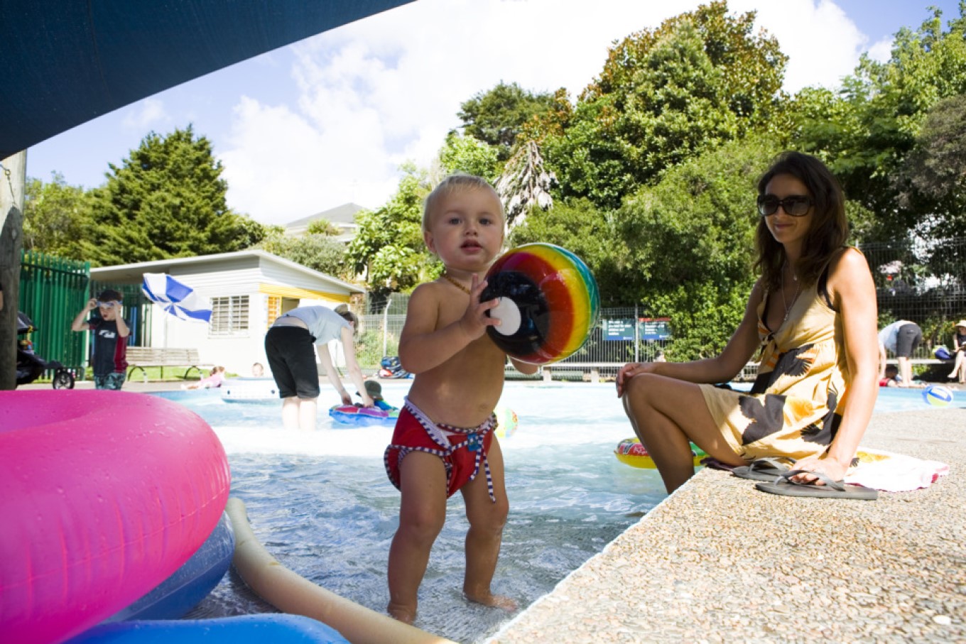 Toddler with ball at pool. 