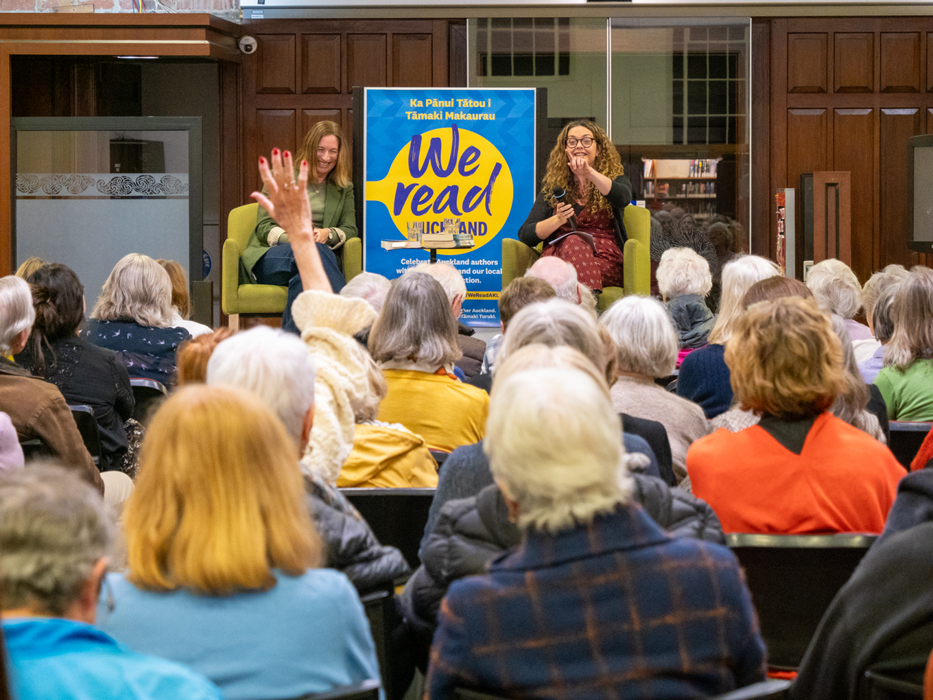 Two women speakers presenting to a crowd. 
