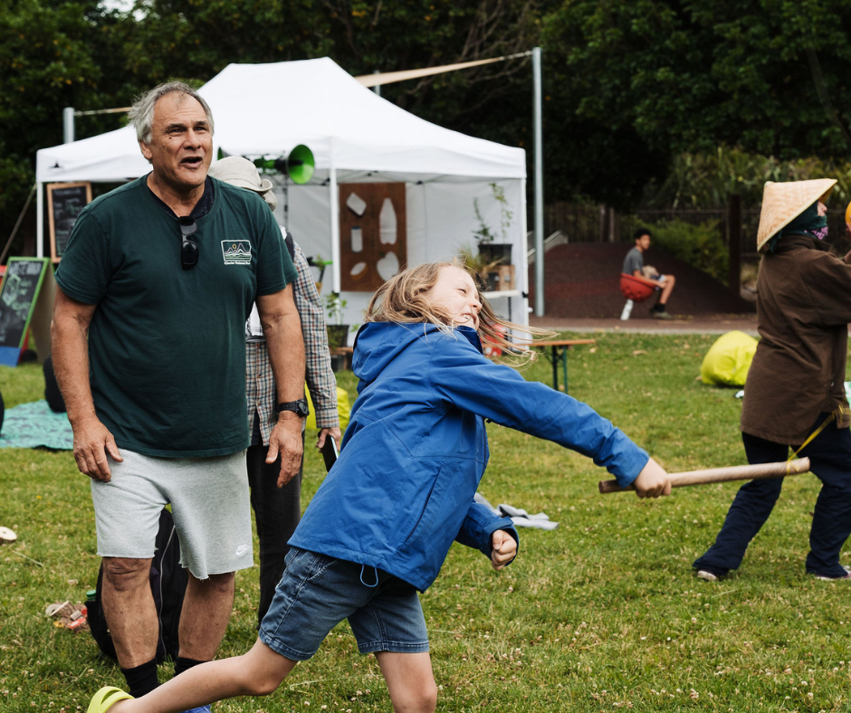 A kid plating games at the park with a older man. 