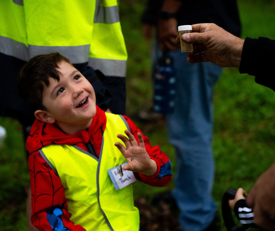 Boy amazed with bug shown to him. 