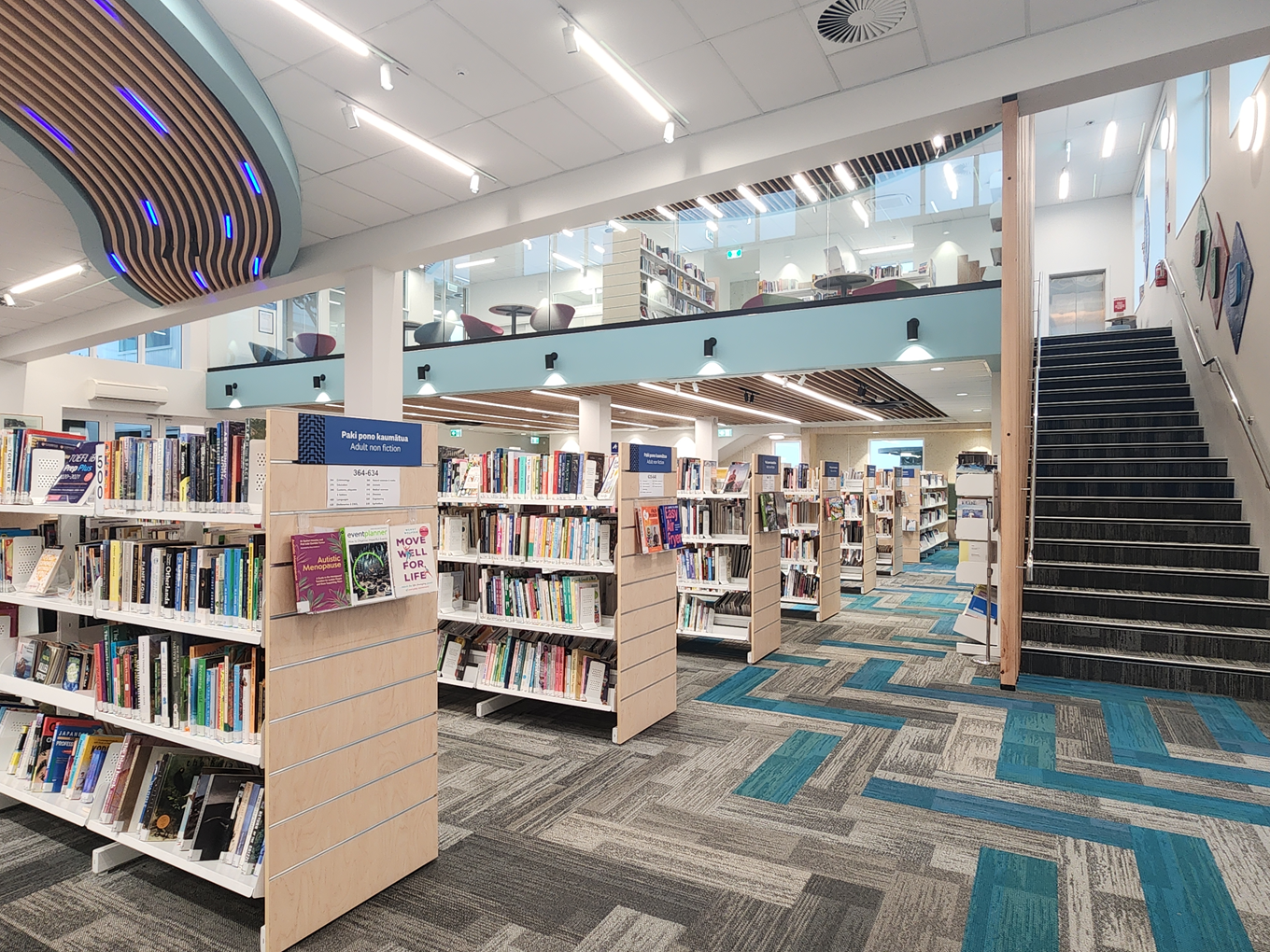 A two level library interior with shelves filled with books. 