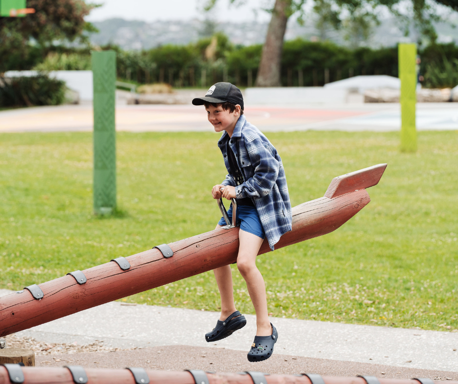 Child playing on a Māori themed seesaw.