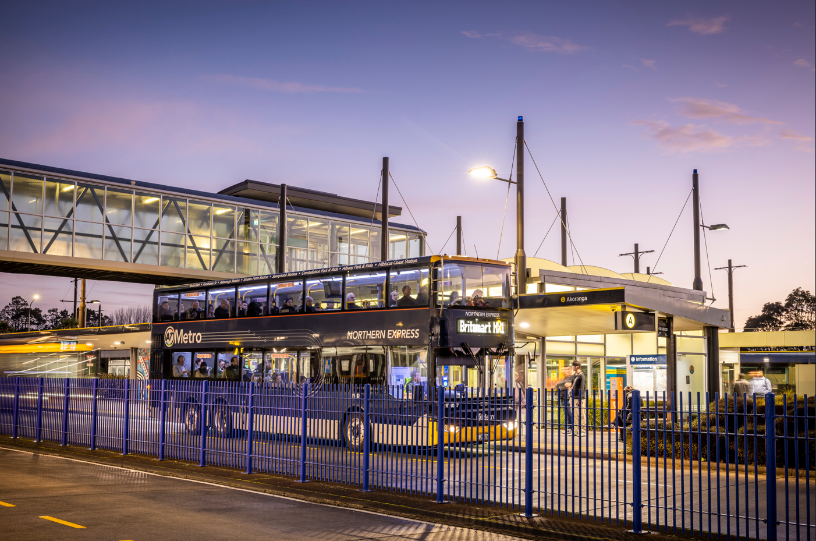 Bus station at night with a double decker bus in the foreground