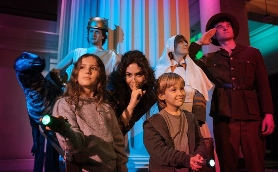 People in costume at the museum after dark.