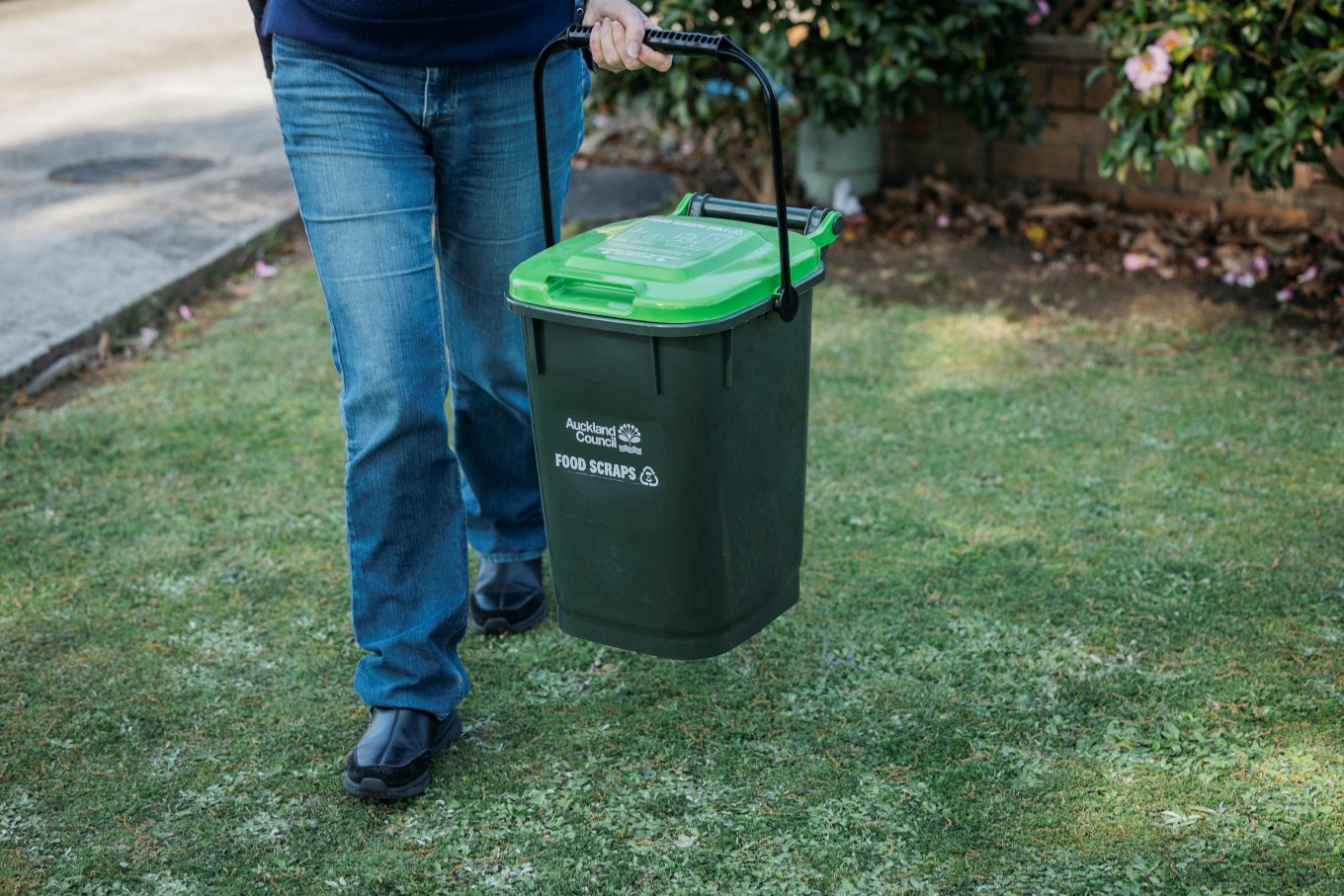 A person taking their food scraps bin out. 