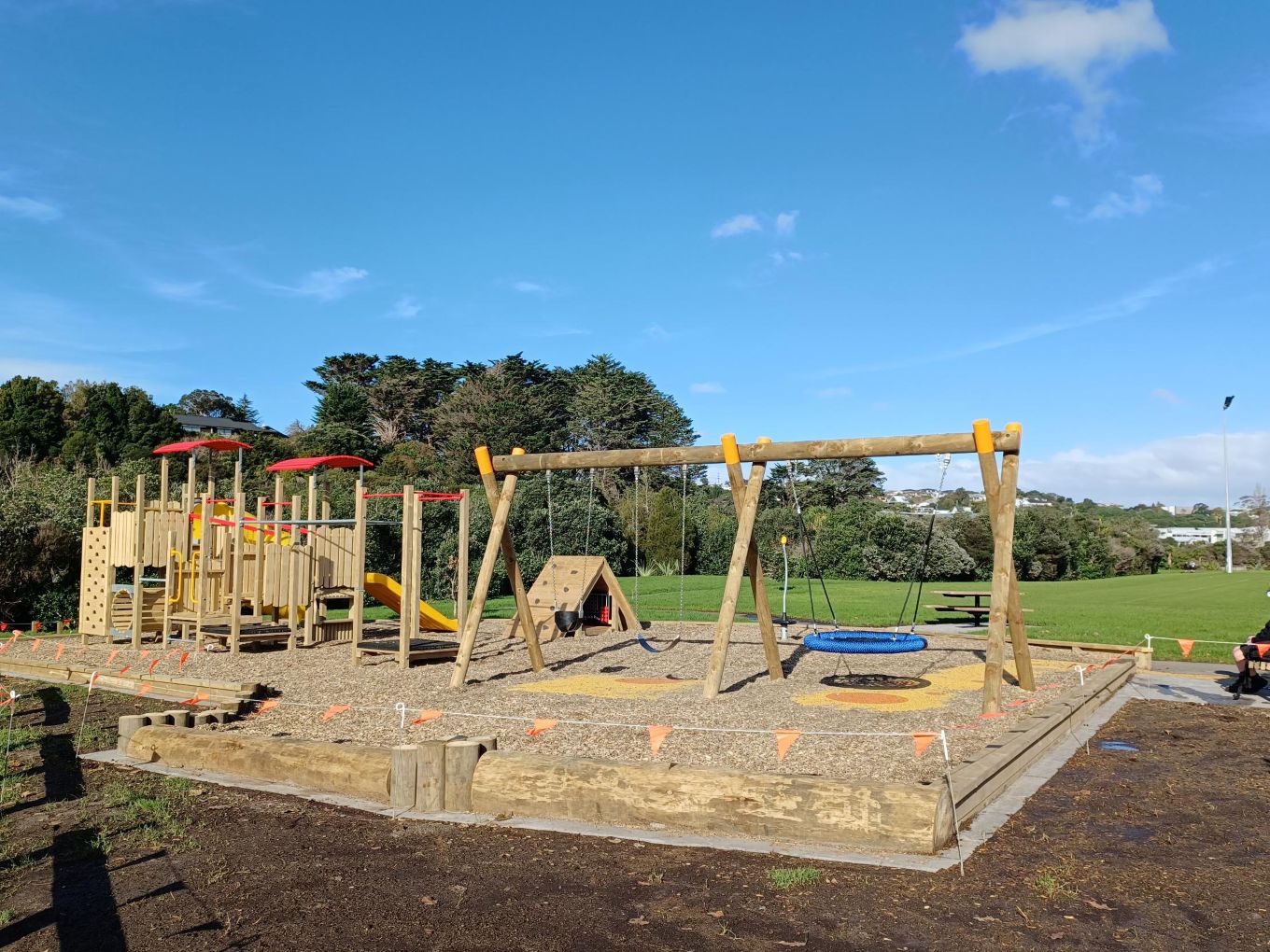A wooden playground with a sandpit. 