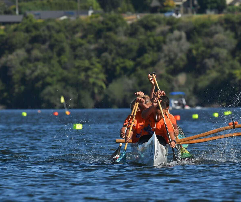 Waka ama team paddling in the water.