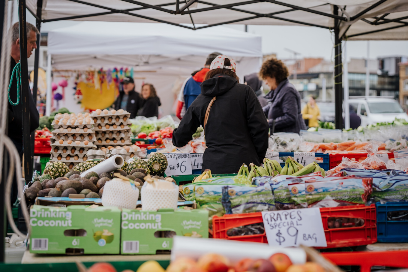 People purchasing produce at a local market. 