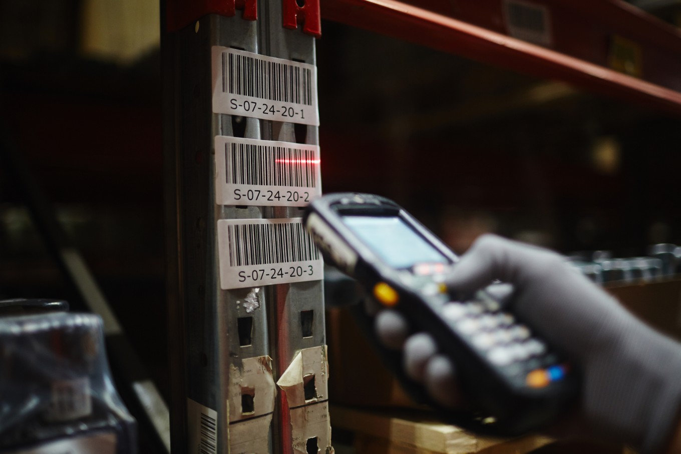 A worker using a device to read barcodes in a factory.