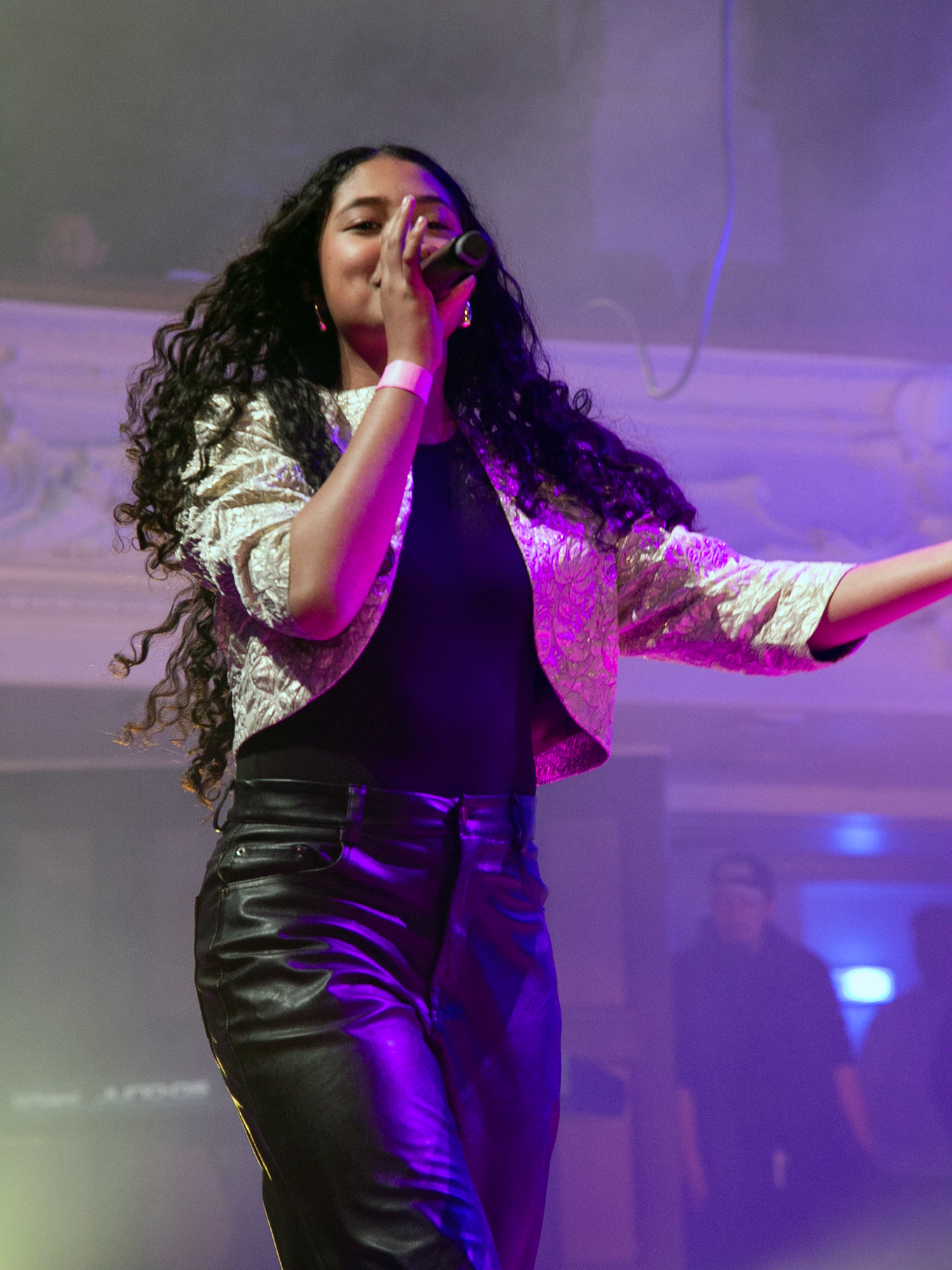 A local musician performing on stage with a microphone in hand. 
