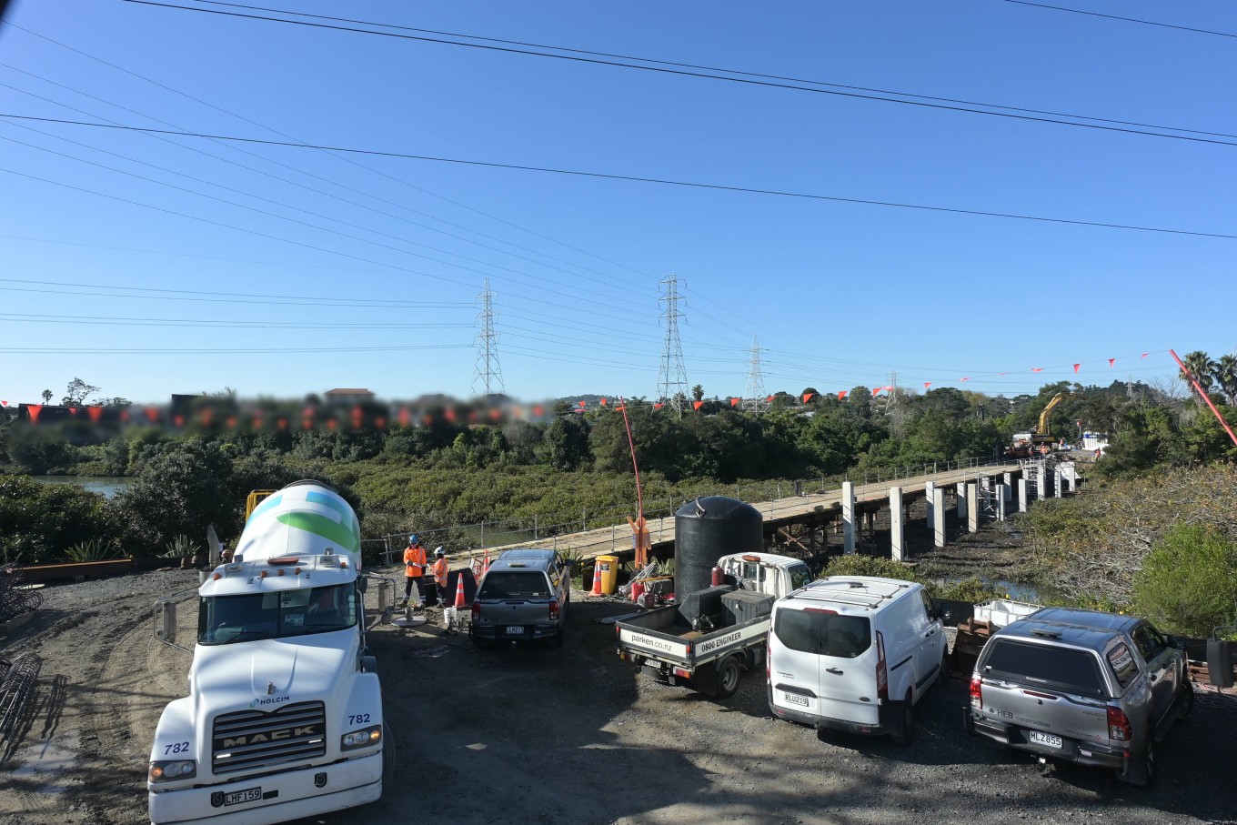 Construction vehicles parked by a creek. 