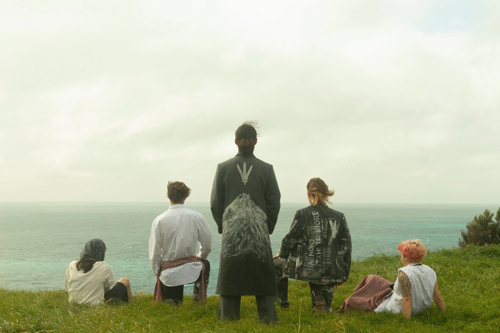 A group of people overlooking the water on a cliffside