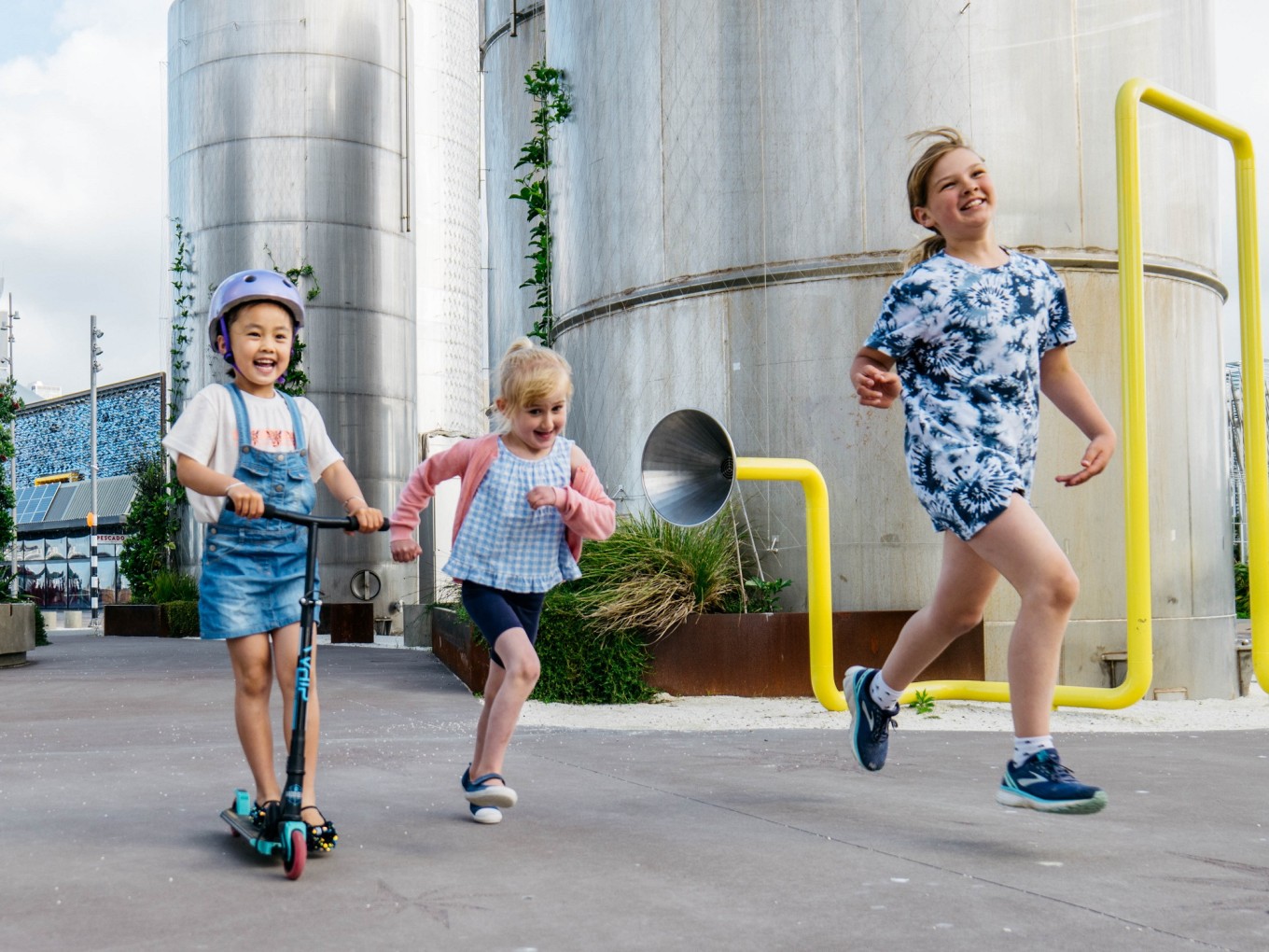Children playing and riding their scoter in a urban enivironment.