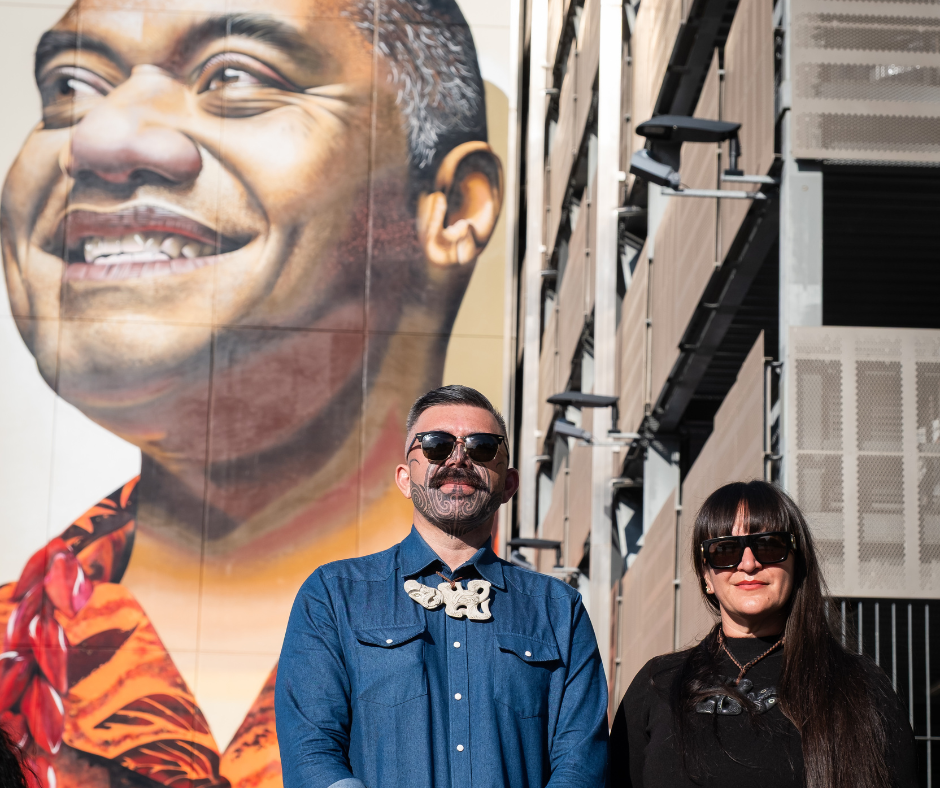 Artists of mural next to their creation. 