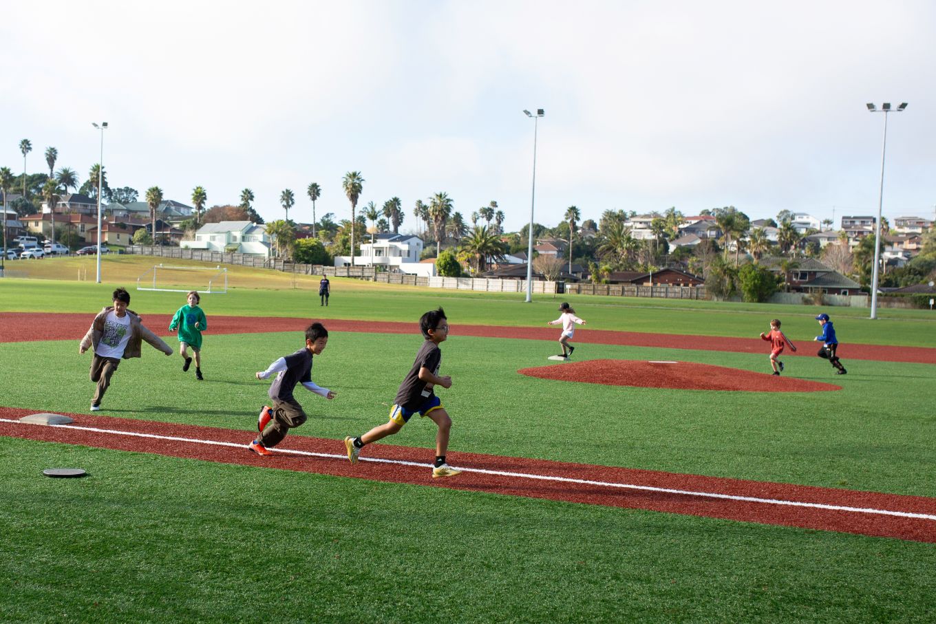 Kids running on the softball field. 