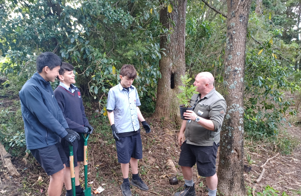 Mahurangi College students with learning in the living classroom with Auckland Council's Frazer Dale.