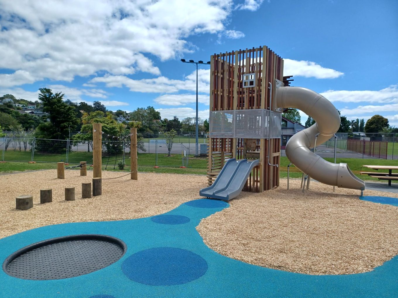 A playground with a slide tower. 