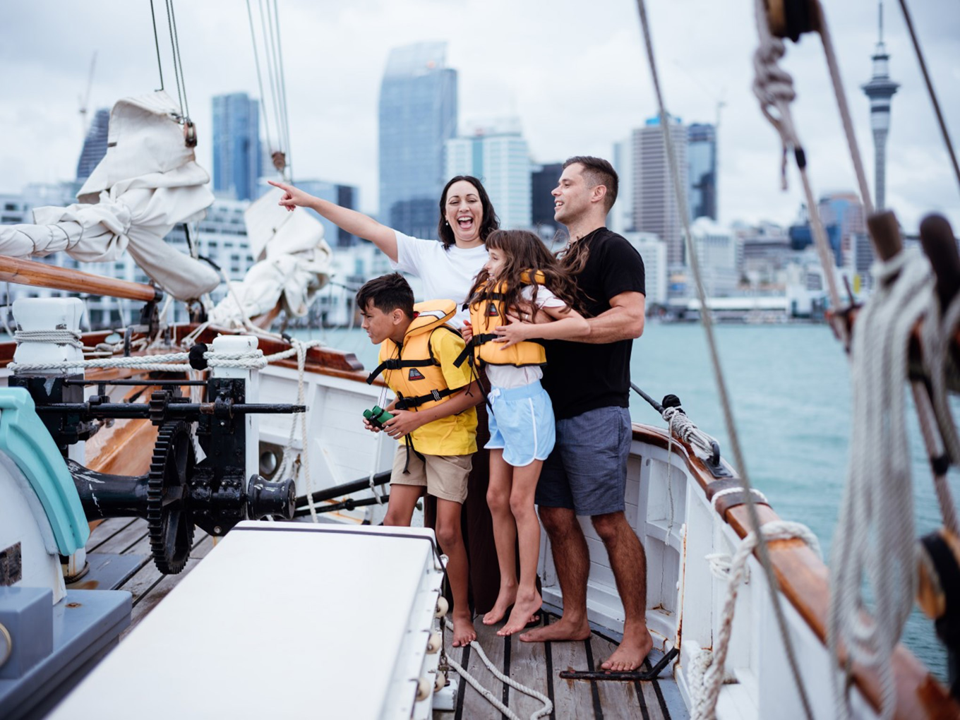 A family on a sailing ship in the water. 