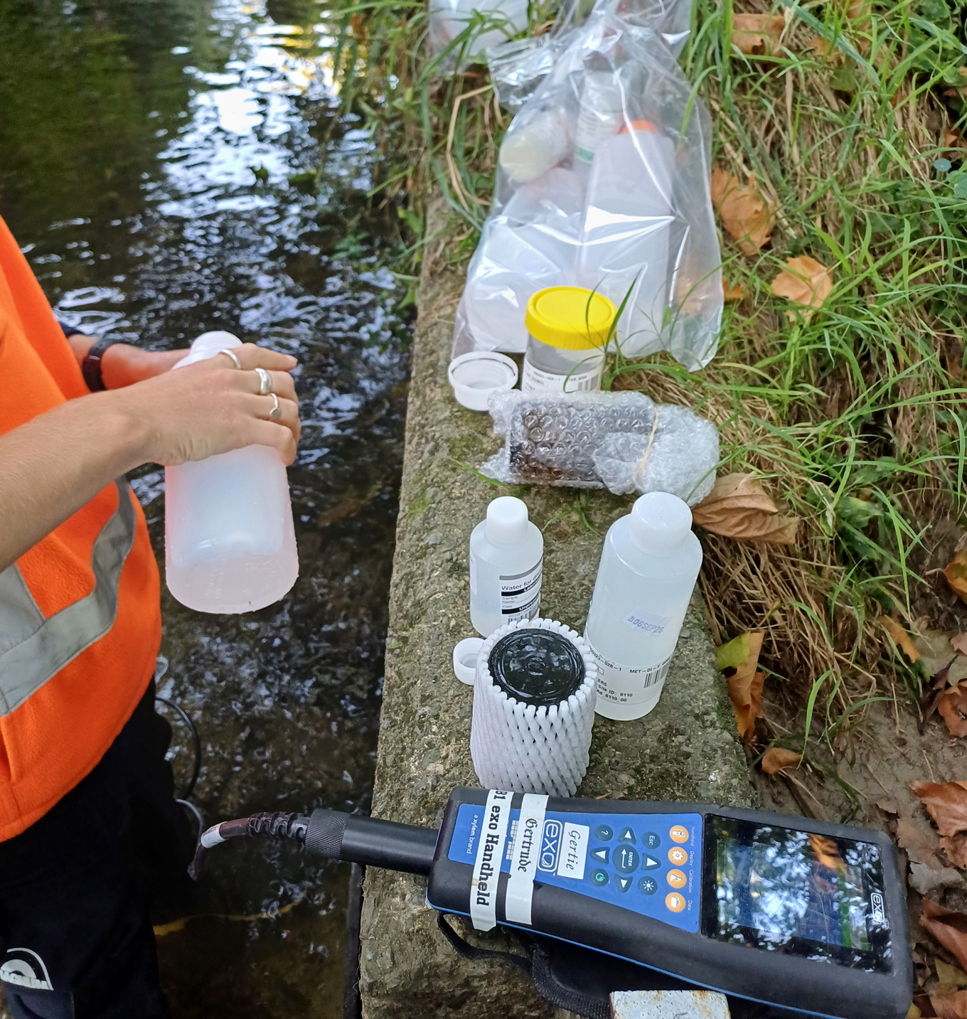 Auckland Council staff members testing the water quality of a local river. 