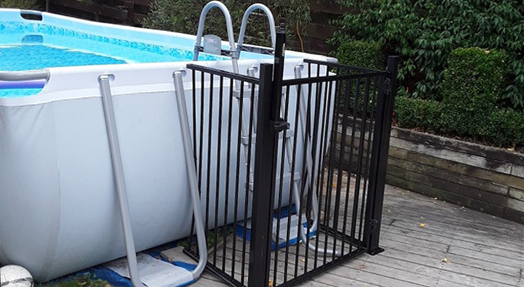 Portable pool with barrier around the ladder 