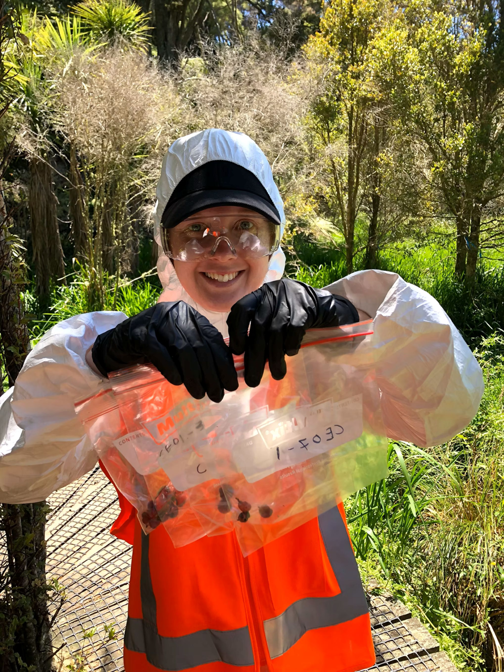 A plant worker holding seeds in bags