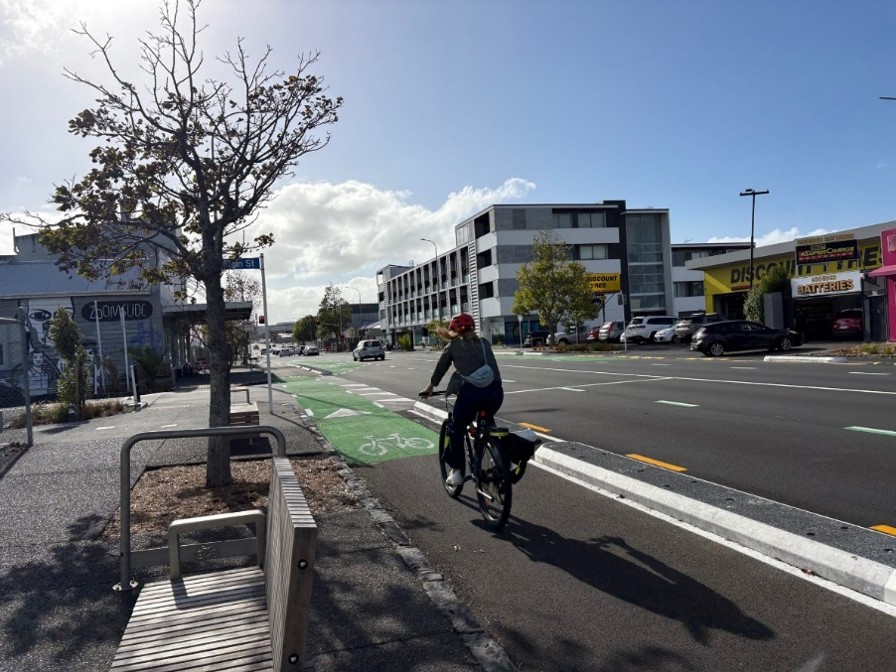 A cyclist riding down a busy street. 