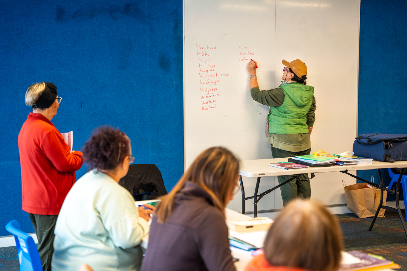 People learning how to speak Māori in a classroom. 