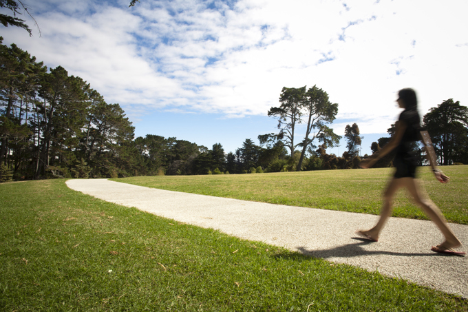 A lady walking down a path at a local park
