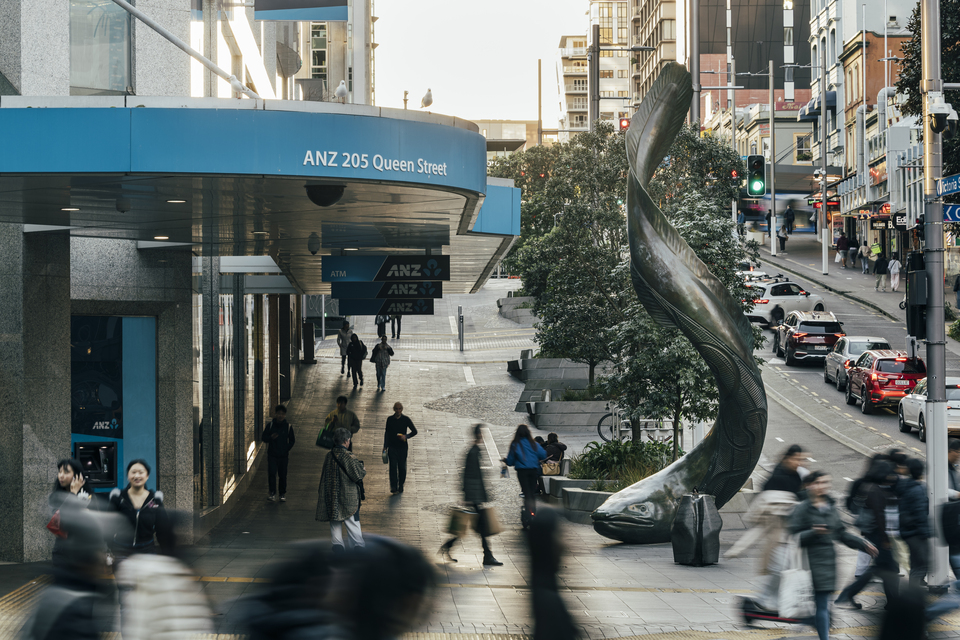 A blurred image of people walking in the city centre with a ell artwork in the centre.