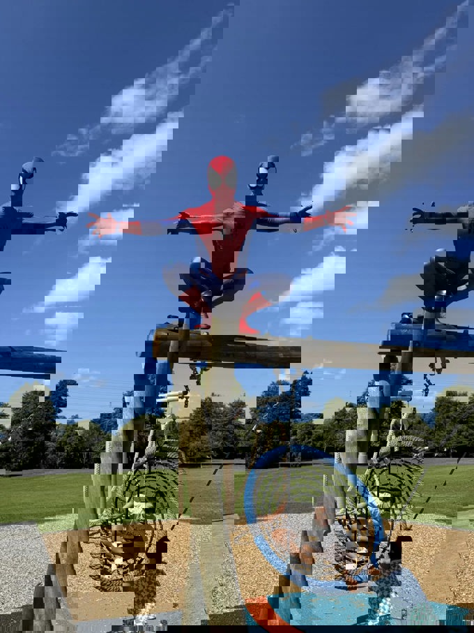 Spider man hanging out at a local playground