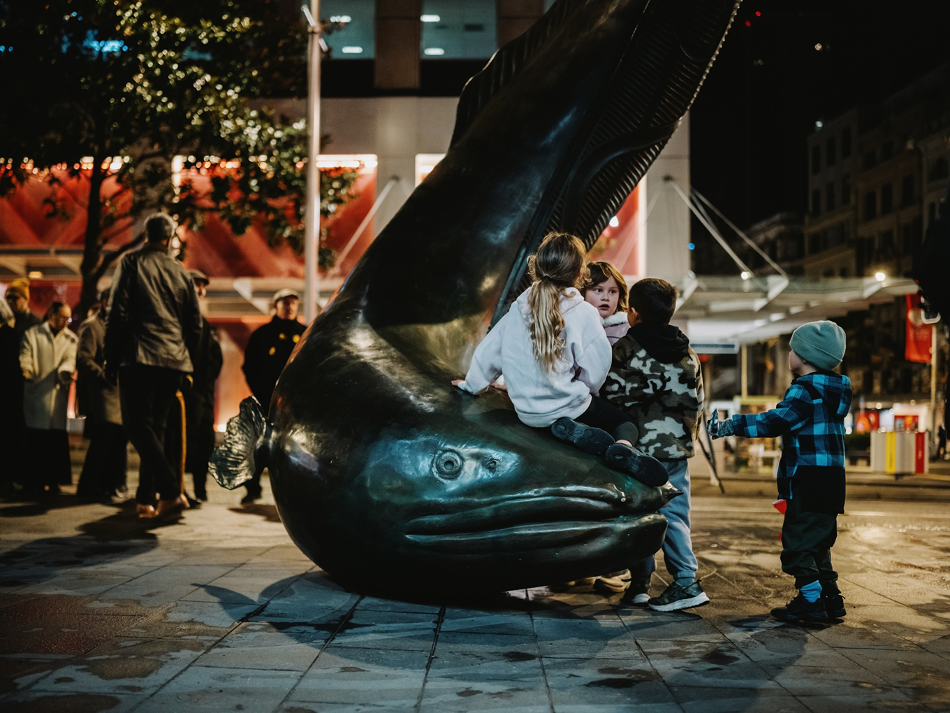 Children playing on a art piece in a urban environment. 