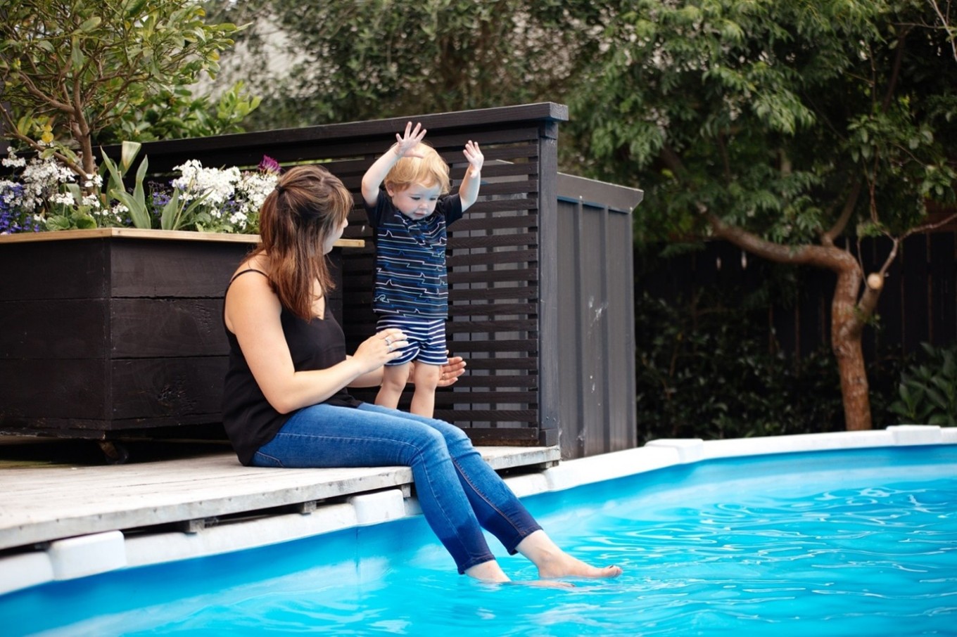 A woman and a small boy near a pool.