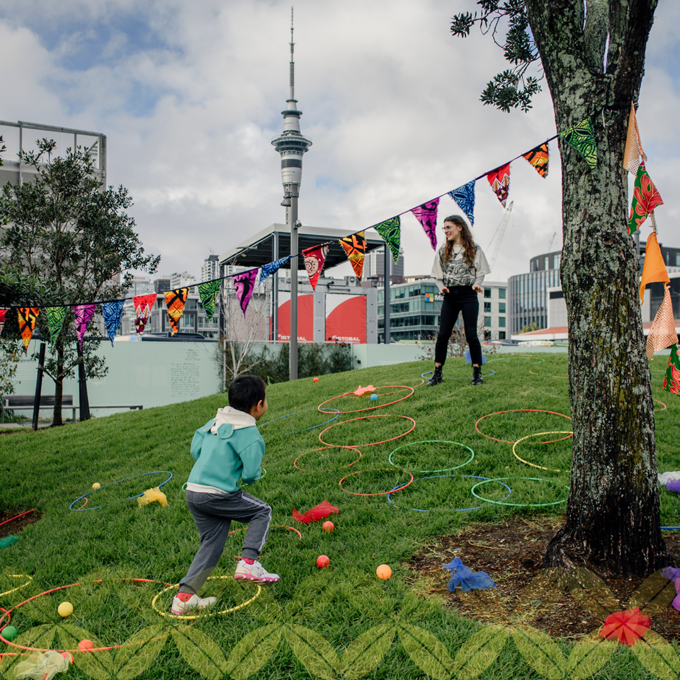 A child jumping through hula hoops on a side of the hill