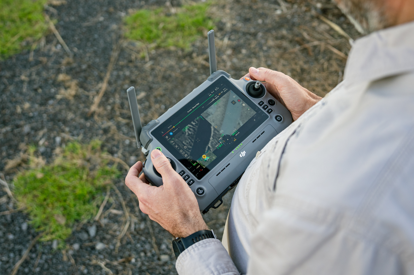 A drone handler using a remote to control a drone.